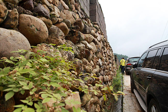 油石鄉(xiāng)梅嶺小學(xué)路口較窄，車隊(duì)只能停在路邊，步行上去
